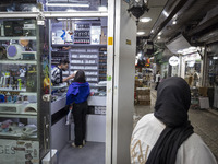 A young Iranian woman who is not wearing a mandatory headscarf shops at a cosmetic shop at a shopping center in Shiraz, Iran, on October 8,...