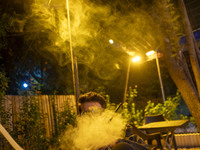 A young Iranian man puffs on a hookah while sitting at a garden-cafe in Shiraz, Iran, on October 7, 2024.  (