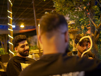 Young Iranian men sit together at a garden-cafe in Shiraz, Iran, on October 7, 2024, while Western countries express concern about a potenti...