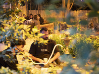 An Iranian man puffs on a hookah while sitting at a garden-cafe in Shiraz, Iran, on October 7, 2024. Western countries express concern about...