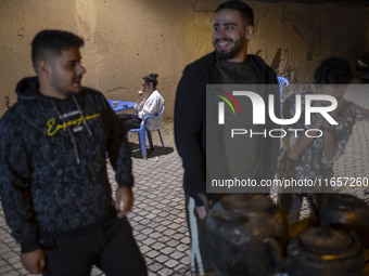 Iranian youths are outside an outdoor cafe in a garden in the city of Shiraz, Iran, on October 7, 2024.  (