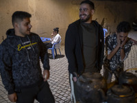 Iranian youths are outside an outdoor cafe in a garden in the city of Shiraz, Iran, on October 7, 2024.  (