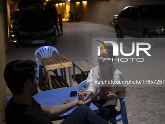 Iranian youths sit at an outdoor cafe in a garden in Shiraz, Iran, on October 7, 2024, while Western countries express concern about a poten...