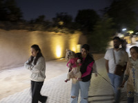 Iranian youths walk along a path while one of them carries her pet in Shiraz, Iran, on October 7, 2024. Western countries express concern ab...