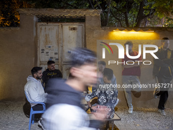 A group of young Iranian men gathers at an outdoor cafe in a garden in Shiraz, Iran, on October 8, 2024, about 932 km (579 miles) south of T...