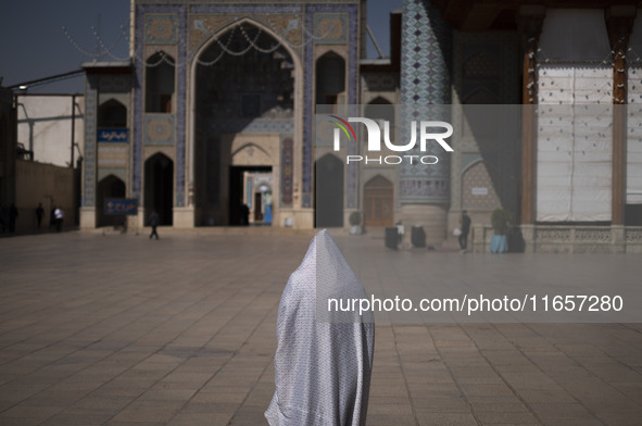 A veiled Iranian woman walks in a holy shrine in Shiraz, Iran, on October 8, 2024. While Western countries express concern about a potential...