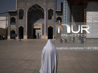 A veiled Iranian woman walks in a holy shrine in Shiraz, Iran, on October 8, 2024. While Western countries express concern about a potential...