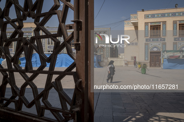 A veiled elderly Iranian woman walks along an area in a holy shrine in Shiraz, Iran, on October 8, 2024. While Western countries express con...