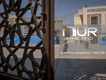 A veiled elderly Iranian woman walks along an area in a holy shrine in Shiraz, Iran, on October 8, 2024. While Western countries express con...