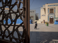 A veiled elderly Iranian woman walks along an area in a holy shrine in Shiraz, Iran, on October 8, 2024. While Western countries express con...