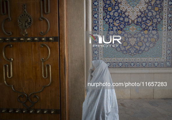 A veiled Iranian woman walks in a holy shrine in Shiraz, Iran, on October 8, 2024. While Western countries express concern about a potential...