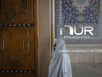 A veiled Iranian woman walks in a holy shrine in Shiraz, Iran, on October 8, 2024. While Western countries express concern about a potential...