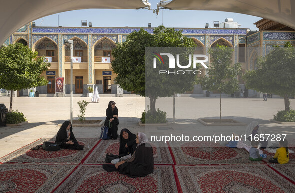 Veiled women sit in a holy shrine in Shiraz, Iran, on October 8, 2024. While Western countries express concern about a potential escalation...