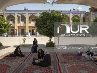 Veiled women sit in a holy shrine in Shiraz, Iran, on October 8, 2024. While Western countries express concern about a potential escalation...