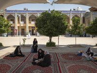 Veiled women sit in a holy shrine in Shiraz, Iran, on October 8, 2024. While Western countries express concern about a potential escalation...