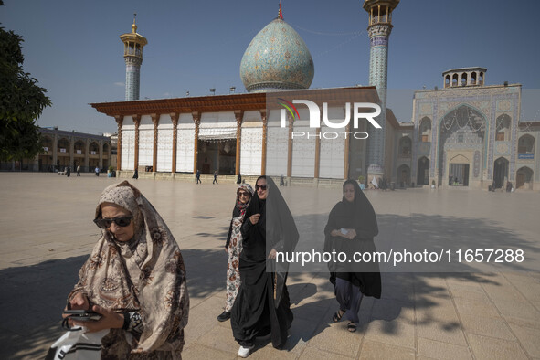 Veiled Iranian women walk along an area in a holy shrine in Shiraz, Iran, on October 8, 2024. Western countries express concern about a pote...