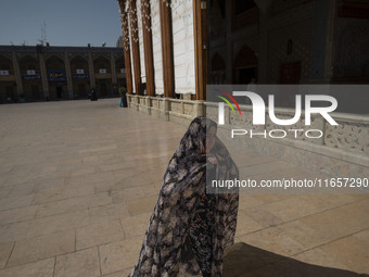 A veiled Iranian woman walks in a holy shrine in Shiraz, Iran, on October 8, 2024. While Western countries express concern about a potential...