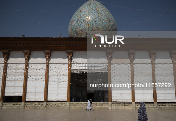 Veiled Iranian women walk along an area in a holy shrine in Shiraz, Iran, on October 8, 2024. Western countries express concern about a pote...