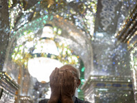 An Iranian man prays next to a tomb in a holy shrine in Shiraz, Iran, on October 8, 2024. While Western countries express concern about a po...