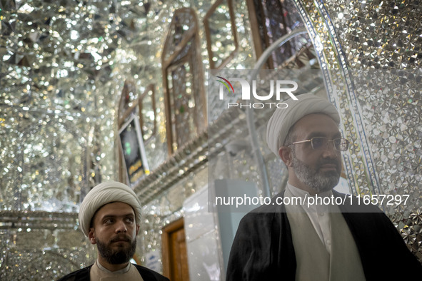 Two Iranian clerics stand next to a tomb in a holy shrine in Shiraz, Iran, on October 8, 2024. While Western countries express concern about...