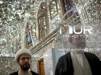 Two Iranian clerics stand next to a tomb in a holy shrine in Shiraz, Iran, on October 8, 2024. While Western countries express concern about...