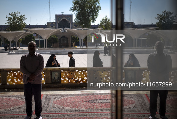 Muslim people pray while standing in a holy shrine in Shiraz, Iran, on October 8, 2024. Western countries express concern about a potential...