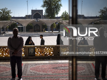 Muslim people pray while standing in a holy shrine in Shiraz, Iran, on October 8, 2024. Western countries express concern about a potential...