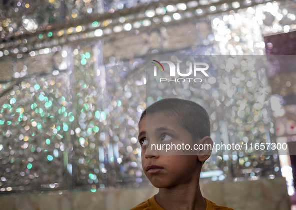 A young Iranian boy stands next to a tomb (not pictured) in a holy shrine in Shiraz, Iran, on October 8, 2024. Western countries express con...