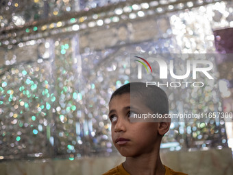 A young Iranian boy stands next to a tomb (not pictured) in a holy shrine in Shiraz, Iran, on October 8, 2024. Western countries express con...