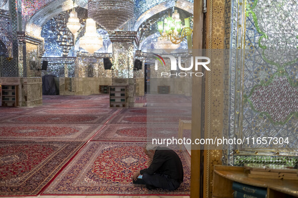 An elderly Iranian man reads a prayer book while sitting in a holy shrine in Shiraz, Iran, on October 8, 2024. Western countries express con...