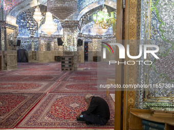 An elderly Iranian man reads a prayer book while sitting in a holy shrine in Shiraz, Iran, on October 8, 2024. Western countries express con...