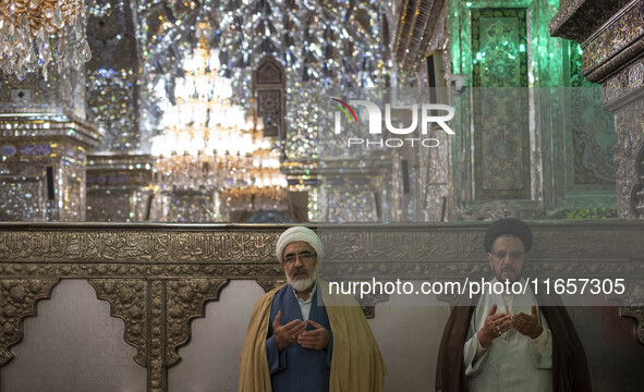 Two Iranian clerics pray next to a tomb in a holy shrine in Shiraz, Iran, on October 8, 2024. Western countries express concern about a pote...