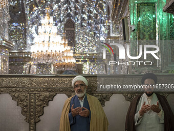 Two Iranian clerics pray next to a tomb in a holy shrine in Shiraz, Iran, on October 8, 2024. Western countries express concern about a pote...