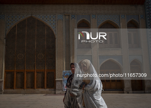 Two veiled Iranian women walk along an area in a holy shrine in Shiraz, Iran, on October 8, 2024. While Western countries express concern ab...