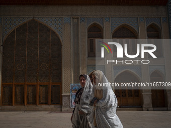 Two veiled Iranian women walk along an area in a holy shrine in Shiraz, Iran, on October 8, 2024. While Western countries express concern ab...