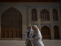 Two veiled Iranian women walk along an area in a holy shrine in Shiraz, Iran, on October 8, 2024. While Western countries express concern ab...