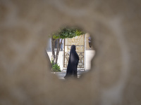 A veiled Iranian woman walks in a holy shrine in Shiraz, Iran, on October 8, 2024. While Western countries express concern about a potential...