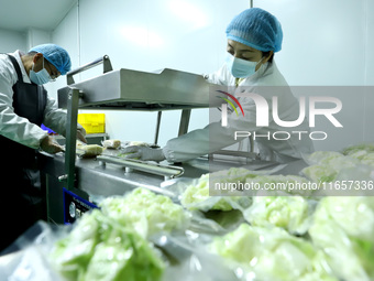 Workers process fresh and purified vegetables for major merchants at a purification processing and distribution line in Zhangye, China, on O...