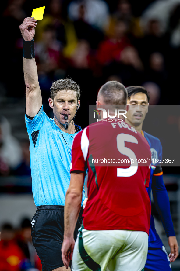 Hungary defender Attila Fiola receives a yellow card from Referee Lukas Fahndrich during the match between Hungary and the Netherlands at th...