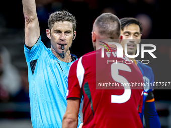 Hungary defender Attila Fiola receives a yellow card from Referee Lukas Fahndrich during the match between Hungary and the Netherlands at th...