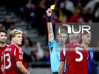 Hungary defender Attila Fiola receives a yellow card from Referee Lukas Fahndrich during the match between Hungary and the Netherlands at th...