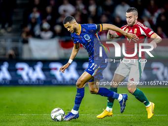 Netherlands forward Cody Gakpo and Hungary defender Endre Botka play during the match between Hungary and the Netherlands at the Puskas Aren...