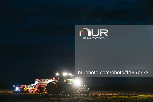 FONTENAY-LE-PESNEL, FRANCE - OCTOBER 11: 
A tractor John Deere 6250R pulls the AEROSEM POTTINGER pneumatic seed drill through a field near F...