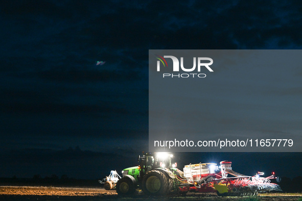 FONTENAY-LE-PESNEL, FRANCE - OCTOBER 11: 
A tractor John Deere 6250R pulls the AEROSEM POTTINGER pneumatic seed drill through a field near F...