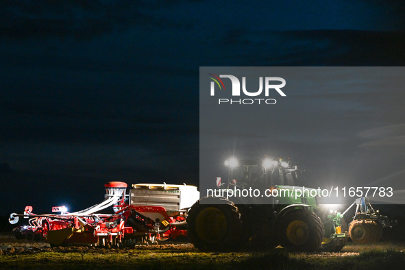 FONTENAY-LE-PESNEL, FRANCE - OCTOBER 11: 
A tractor John Deere 6250R pulls the AEROSEM POTTINGER pneumatic seed drill through a field near F...