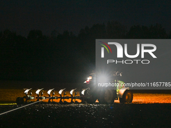 FONTENAY-LE-PESNEL, FRANCE - OCTOBER 11: 
A tractor plows the field with a heavy plough on an October night near Fontenay-le-Pesnel, Calvado...