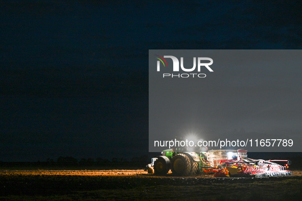 FONTENAY-LE-PESNEL, FRANCE - OCTOBER 11: 
A tractor John Deere 6250R pulls the AEROSEM POTTINGER pneumatic seed drill through a field near F...