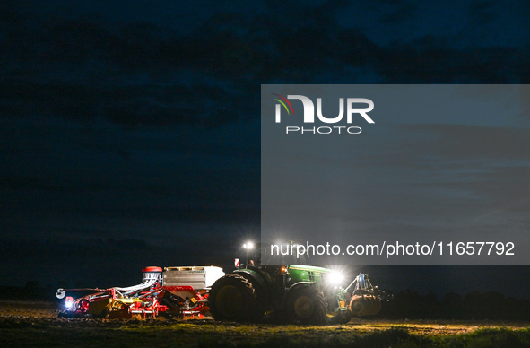 FONTENAY-LE-PESNEL, FRANCE - OCTOBER 11: 
A tractor John Deere 6250R pulls the AEROSEM POTTINGER pneumatic seed drill through a field near F...