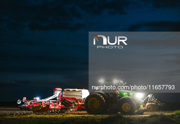 FONTENAY-LE-PESNEL, FRANCE - OCTOBER 11: 
A tractor John Deere 6250R pulls the AEROSEM POTTINGER pneumatic seed drill through a field near F...