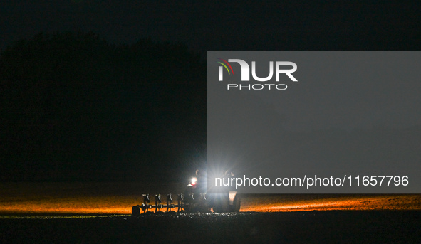 FONTENAY-LE-PESNEL, FRANCE - OCTOBER 11: 
A tractor plows the field with a heavy plough on an October night near Fontenay-le-Pesnel, Calvado...